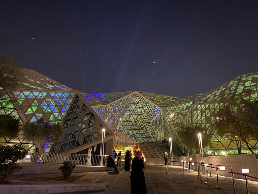 a group of people standing outside of a building at night